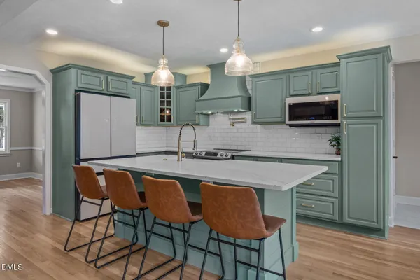 a kitchen with stainless steel appliances granite countertop a kitchen island a stove and a refrigerator