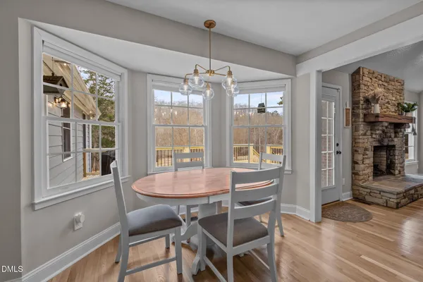 a dining room with furniture a chandelier and wooden floor