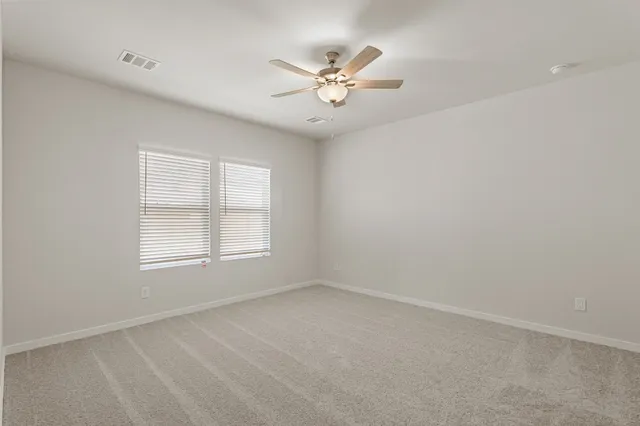 an empty room with a window and a fan