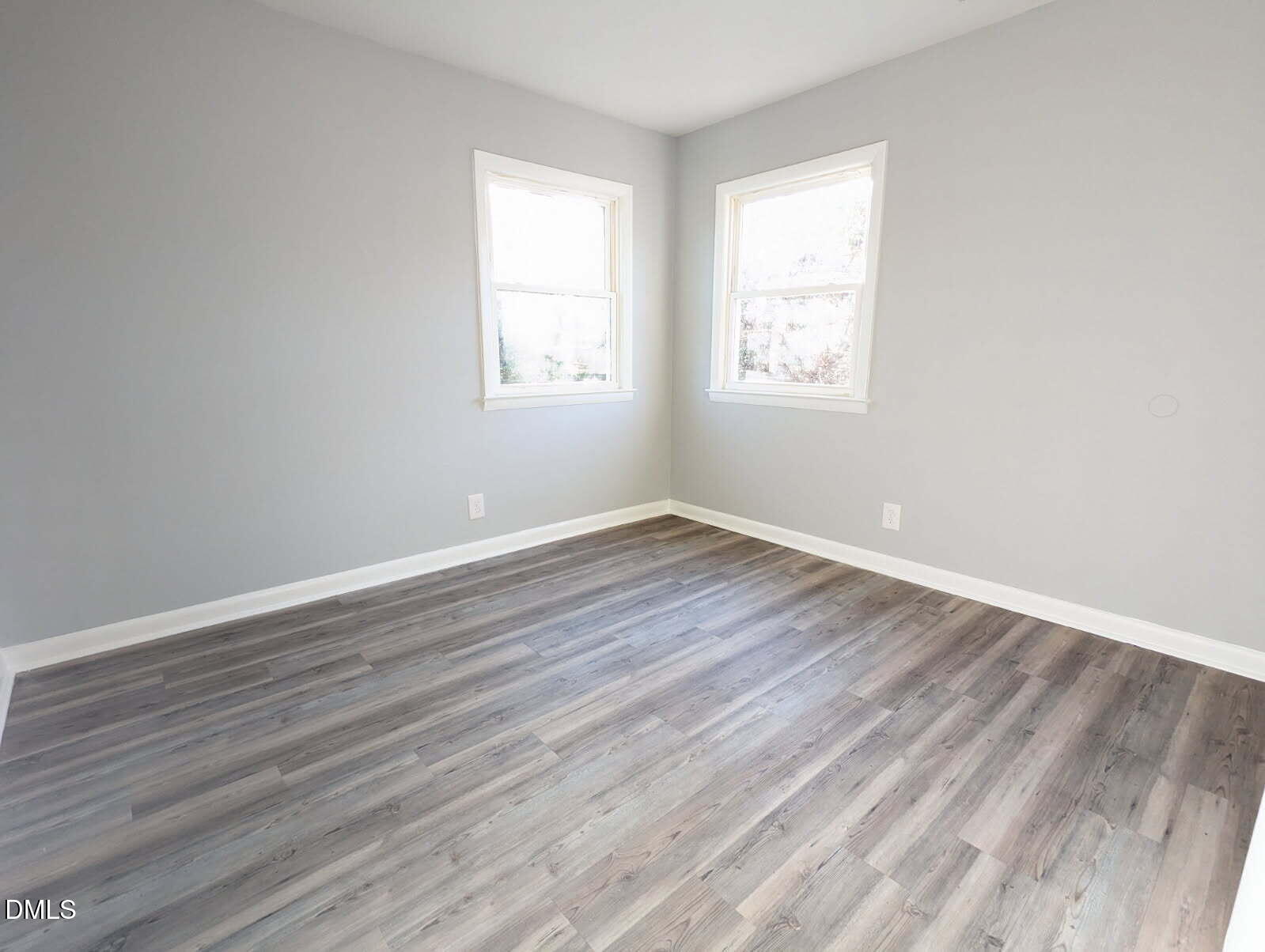 303 Stancil Street Smithfield, NC 27577 - Photo 10 of 13 an empty room with wooden floor and windows