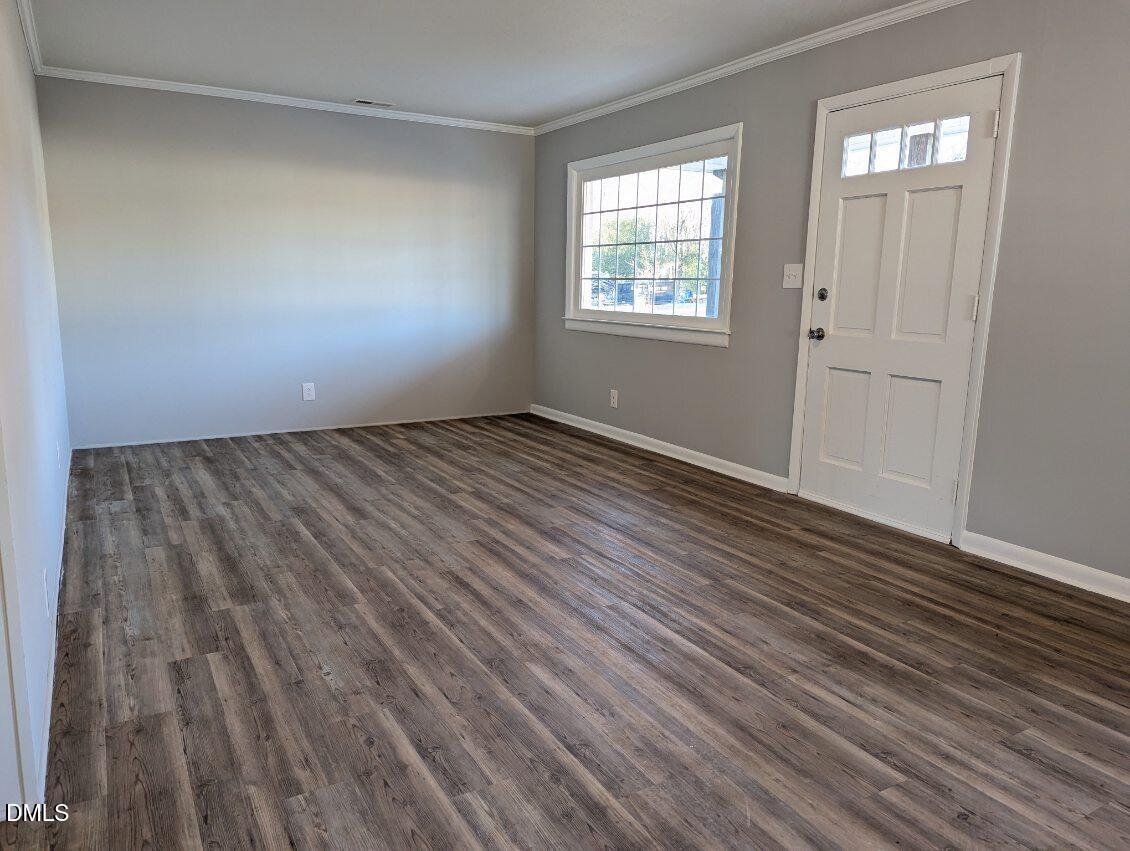 303 Stancil Street Smithfield, NC 27577 - Photo 4 of 13 an empty room with wooden floor and windows