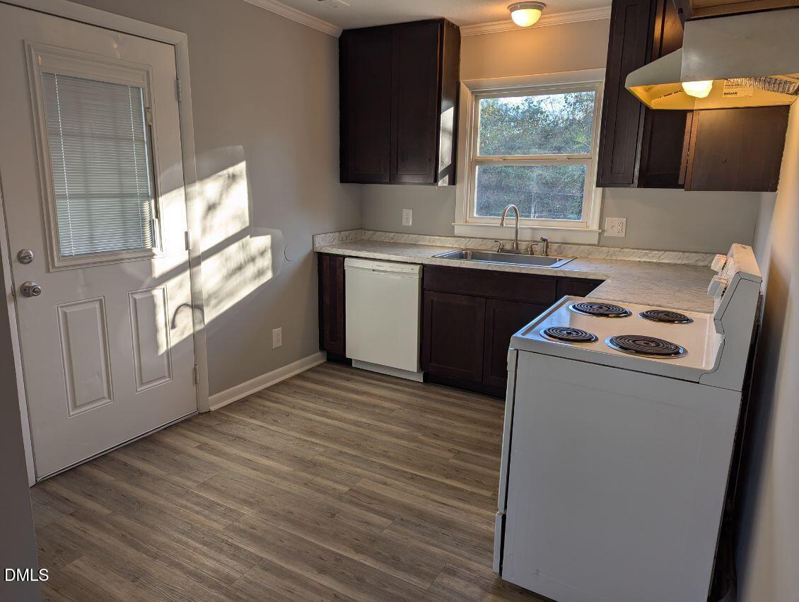 303 Stancil Street Smithfield, NC 27577 - Photo 7 of 13 a kitchen with a sink a stove cabinets and a wooden floor