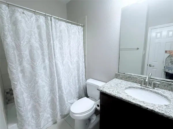 a en suite bathroom with a granite countertop sink and a mirror