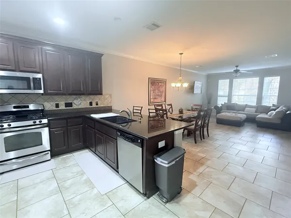 a kitchen with stainless steel appliances granite countertop a refrigerator stove and sink