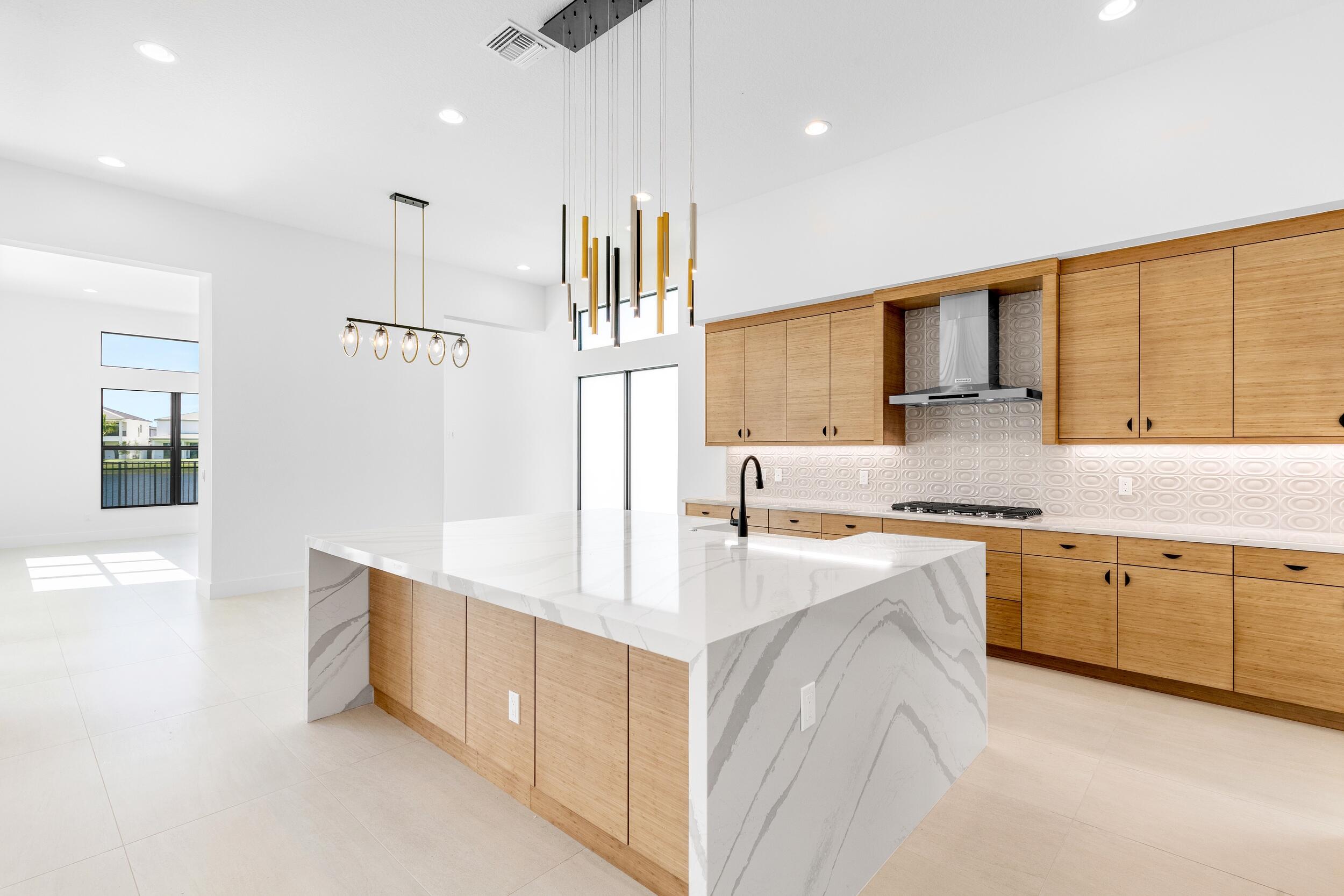 9893 Espresso Manor Boca Raton, FL 33496 - Photo 38 of 71 a large kitchen with stainless steel appliances a large counter top a sink a stove and a refrigerator