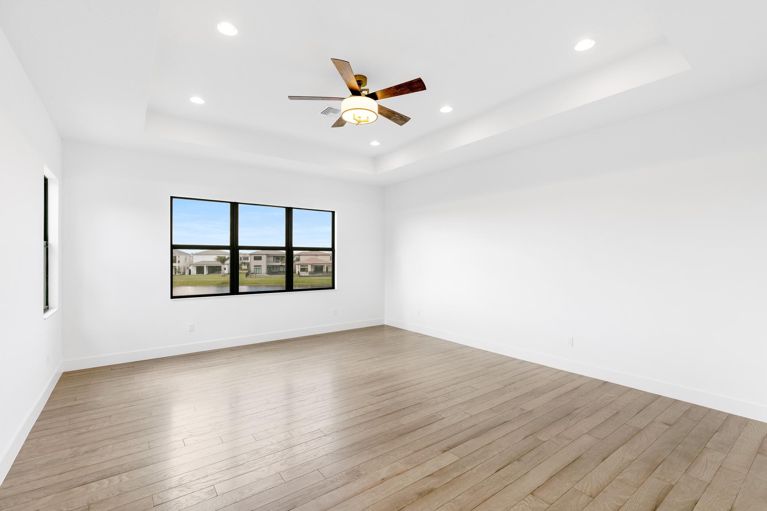 9893 Espresso Manor Boca Raton, FL 33496 - Photo 62 of 71 a view of an empty room with wooden floor and a window