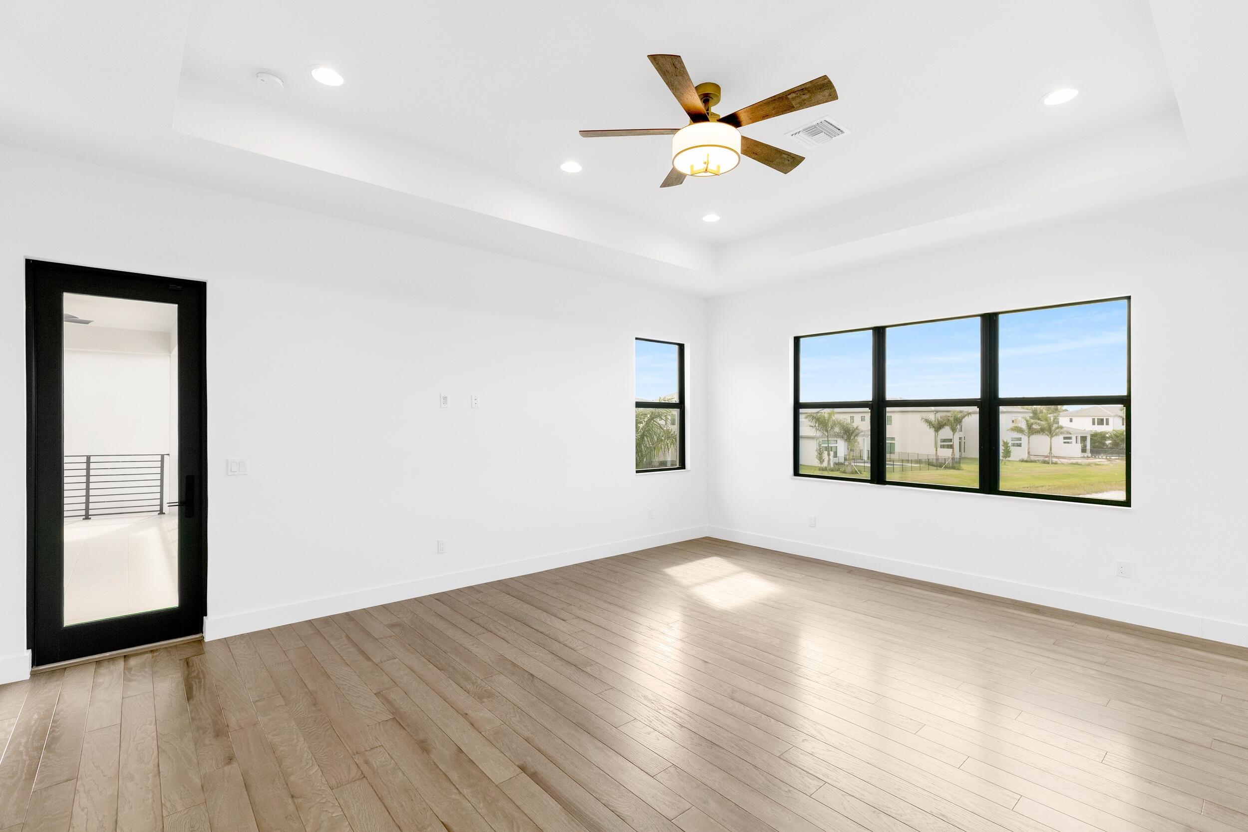 9893 Espresso Manor Boca Raton, FL 33496 - Photo 63 of 71 an empty room with wooden floor chandelier and windows