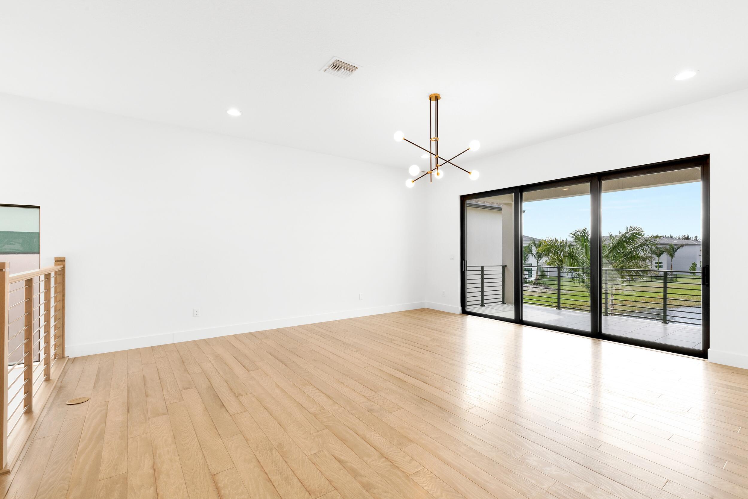9893 Espresso Manor Boca Raton, FL 33496 - Photo 69 of 71 a view of an empty room with wooden floor and a window