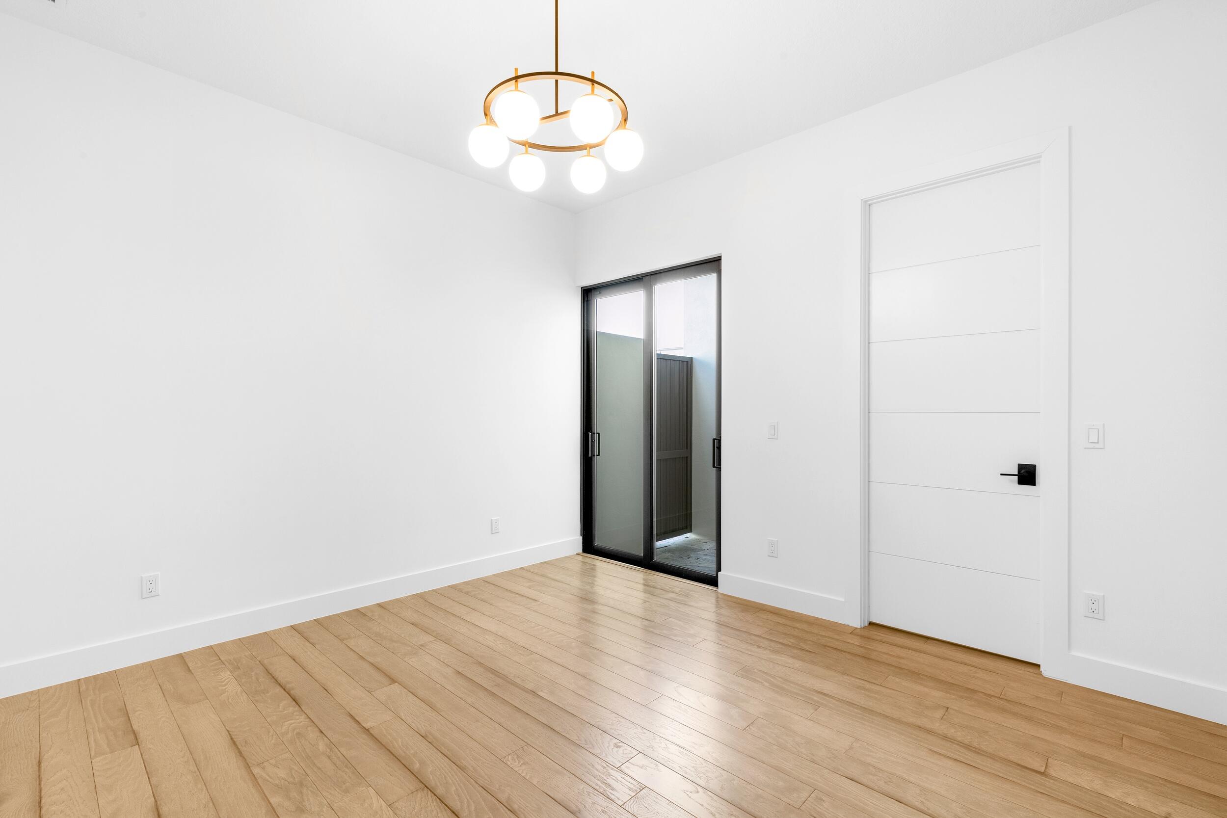 9893 Espresso Manor Boca Raton, FL 33496 - Photo 9 of 71 an empty room with wooden floor and windows