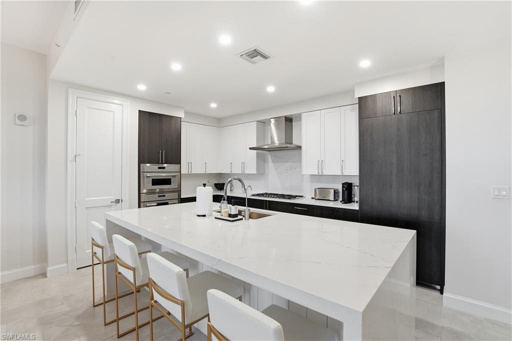 1125 Central Avenue, Unit 469 Naples, FL 34102 - Photo 13 of 38 a kitchen with a sink a stove a refrigerator a kitchen island and chairs