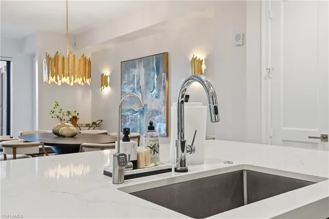 a kitchen with a sink cabinets and chandelier