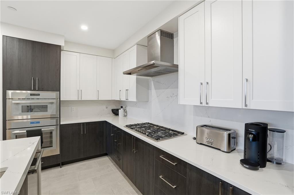 1125 Central Avenue, Unit 469 Naples, FL 34102 - Photo 16 of 38 a kitchen with stainless steel appliances granite countertop a sink stove and refrigerator