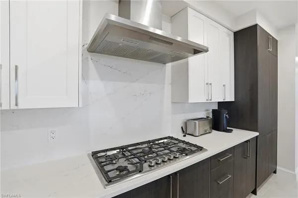 a kitchen with a stove and white cabinets