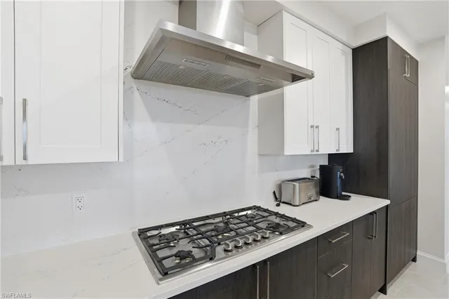 a kitchen with a stove and white cabinets