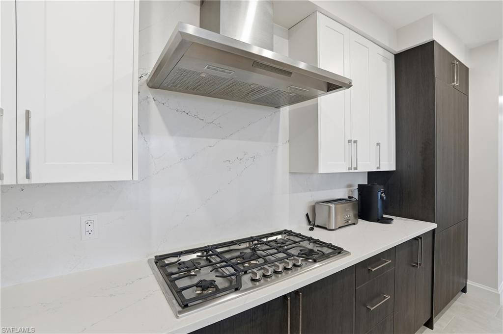 1125 Central Avenue, Unit 469 Naples, FL 34102 - Photo 17 of 38 a kitchen with a stove and white cabinets