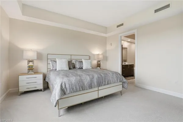 a spacious bedroom with a bed and a lamp