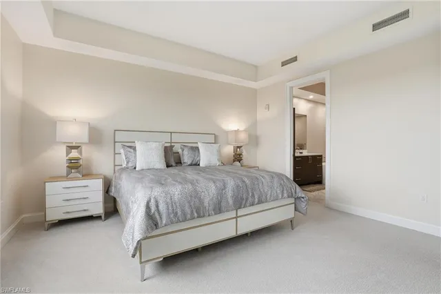 a spacious bedroom with a bed and a lamp