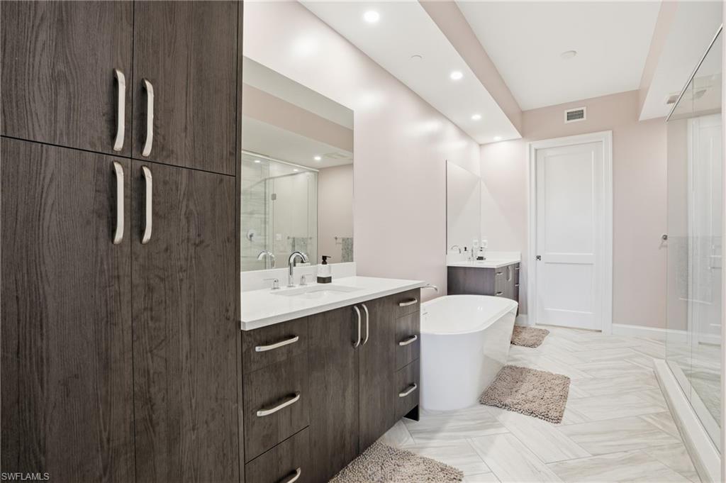 1125 Central Avenue, Unit 469 Naples, FL 34102 - Photo 22 of 38 a bathroom with a double vanity sink toilet and mirror