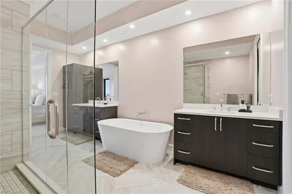a spacious bathroom with a bathtub shower sink mirror and toilet