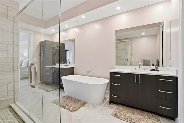 a spacious bathroom with a bathtub shower sink mirror and toilet