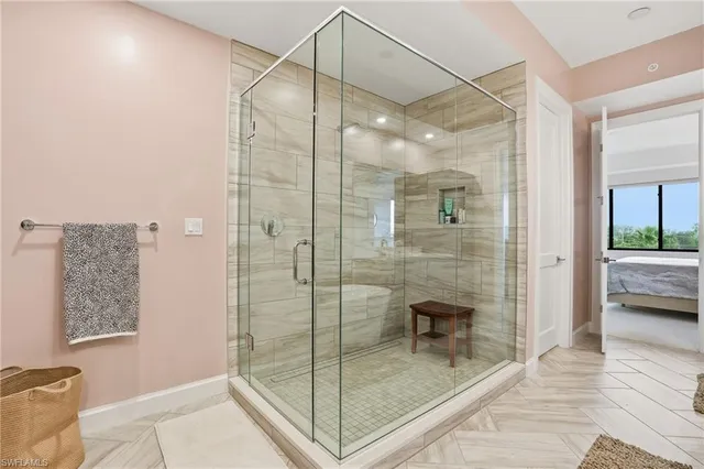 a bathroom with a glass shower door and a glass door