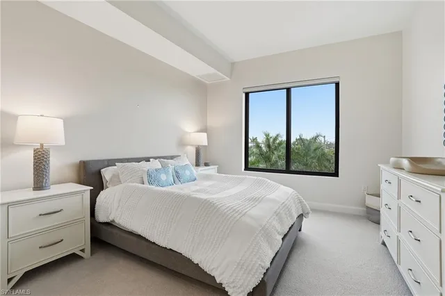 a bedroom with a bed and a dresser next to a window