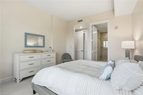a bedroom with a bed and a mirror on dresser