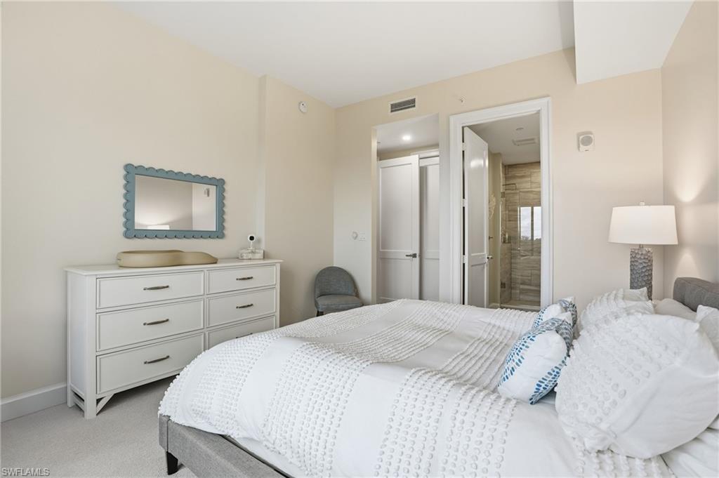 1125 Central Avenue, Unit 469 Naples, FL 34102 - Photo 27 of 38 a bedroom with a bed and a mirror on dresser