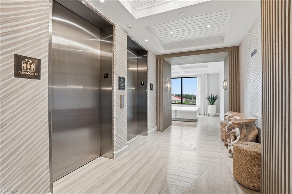 1125 Central Avenue, Unit 469 Naples, FL 34102 - Photo 38 of 38 a view of a hallway with wooden floor and furniture