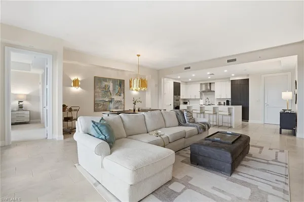 a living room with furniture and view of kitchen