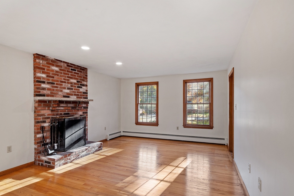 69 Blanchard Street Andover, MA 01810 - Photo 8 of 29 a view of an empty room with exposed radiator and fireplace