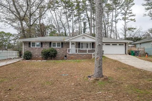 a front view of a house with a garden and trees