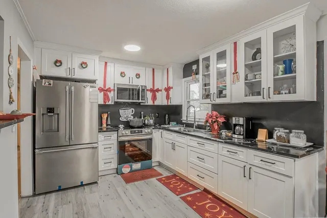 a kitchen with a refrigerator and white cabinets