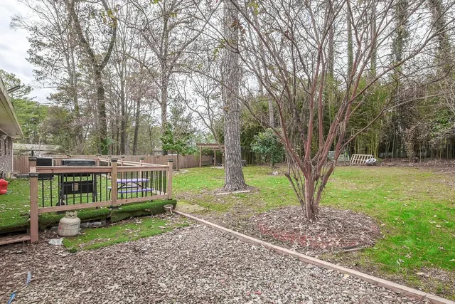 a view of a house with backyard and trees