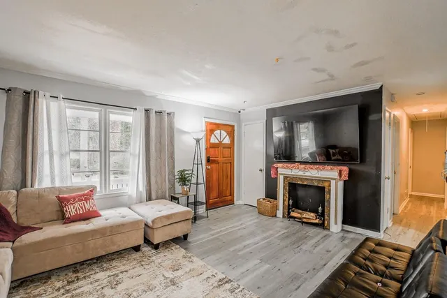 a living room with furniture a flat screen tv and a fireplace