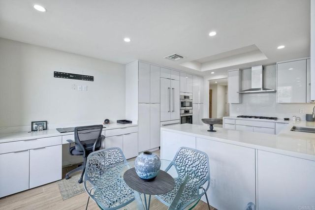 a kitchen with stainless steel appliances granite countertop a sink a stove a dining table and chairs