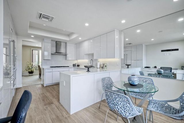 a kitchen with granite countertop kitchen island stainless steel appliances a sink a stove a dining table and chairs