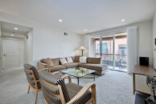 a living room with furniture a flat screen tv and a large window