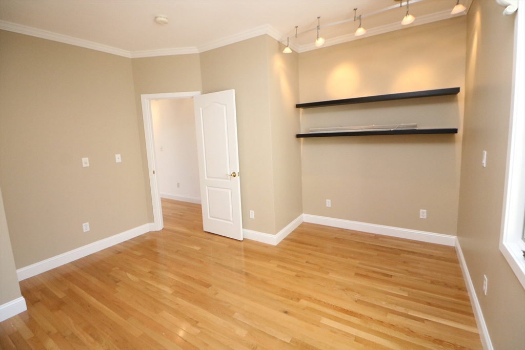 141 Grovers Avenue, Unit 141 Winthrop, MA 02152 - Photo 8 of 21 an empty room with wooden floor and a bathroom