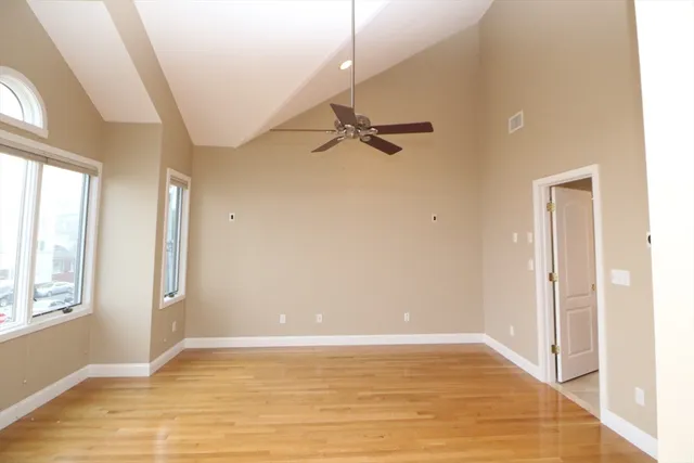 a view of a room with wooden floor and a ceiling fan