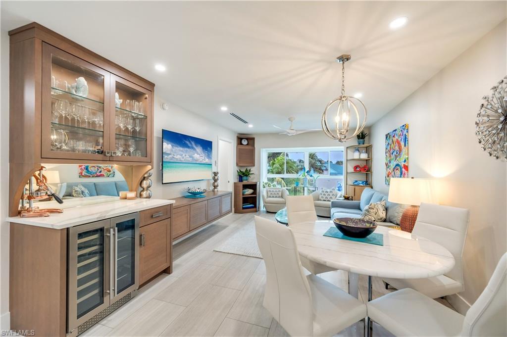 1021 3rd Street South, Unit 310 Naples, FL 34102 - Photo 1 of 27 Dining space featuring wine cooler, a dry bar, a chandelier, recessed lighting, and a ceiling fan