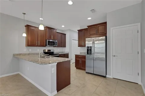 a kitchen with stainless steel appliances granite countertop a refrigerator microwave and sink