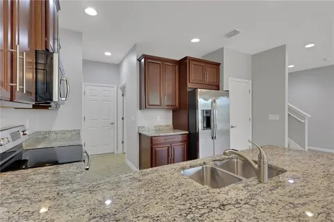 a kitchen with stainless steel appliances granite countertop a sink refrigerator and microwave