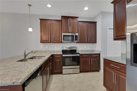 a kitchen with granite countertop stainless steel appliances and wooden cabinets