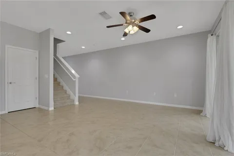 an empty room with a ceiling fan and a window