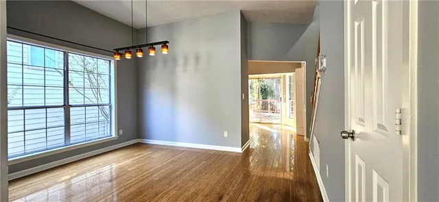 a view of a hallway with wooden floor and stairs