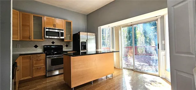 a kitchen with stainless steel appliances a stove top oven a sink and a refrigerator