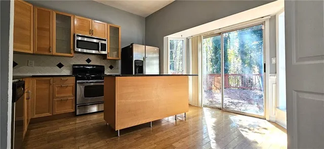 a kitchen with stainless steel appliances a stove top oven a sink and a refrigerator