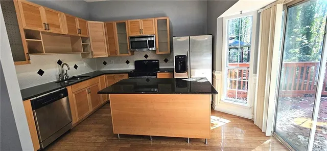 a kitchen with stainless steel appliances granite countertop a stove a sink and a refrigerator