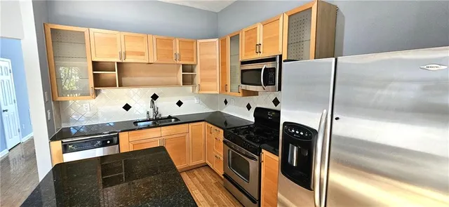 a kitchen with stainless steel appliances a refrigerator sink and stove